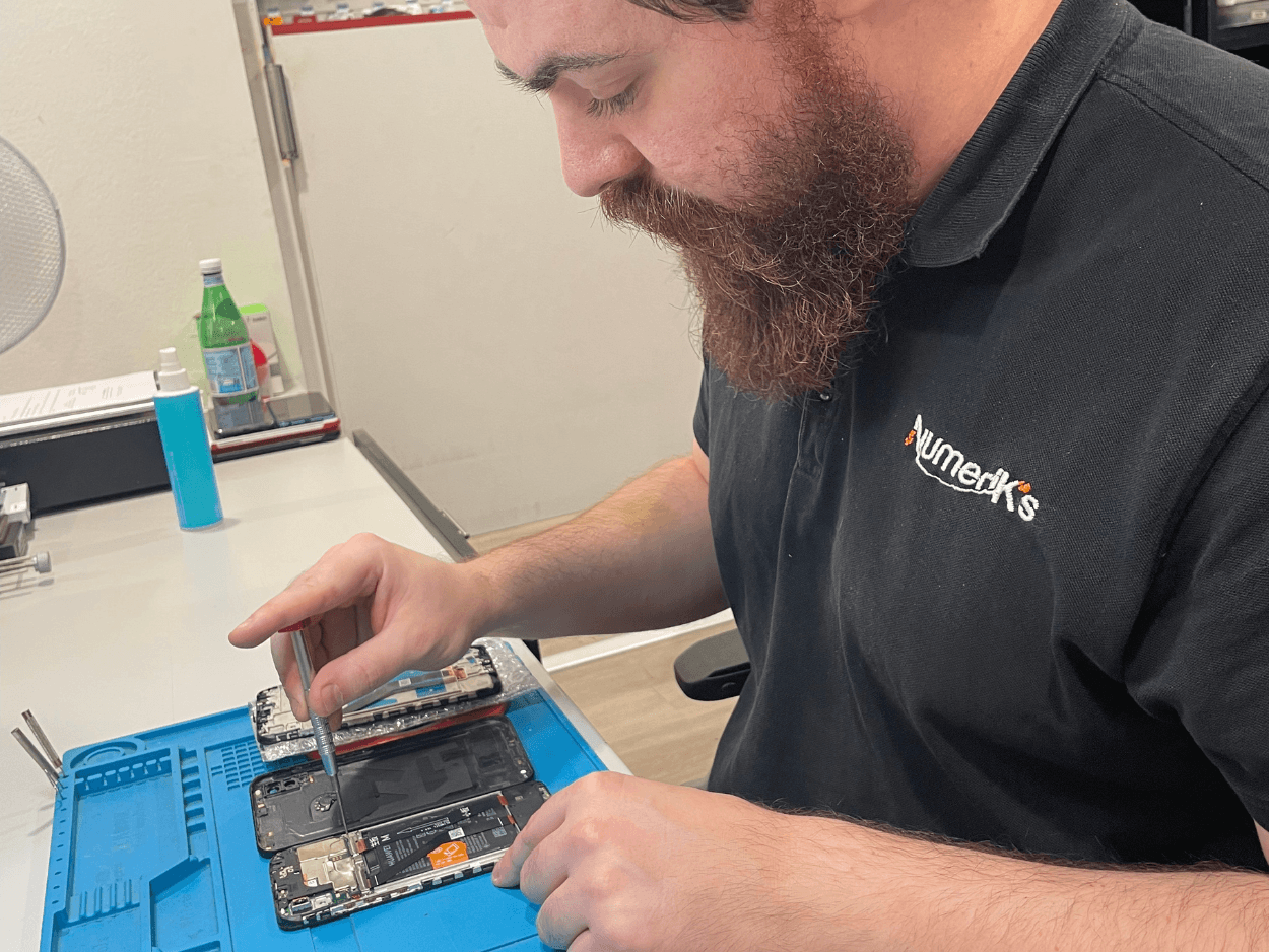 Réparation d'un smartphone en micro-soudure sur un tapis d'atelier
